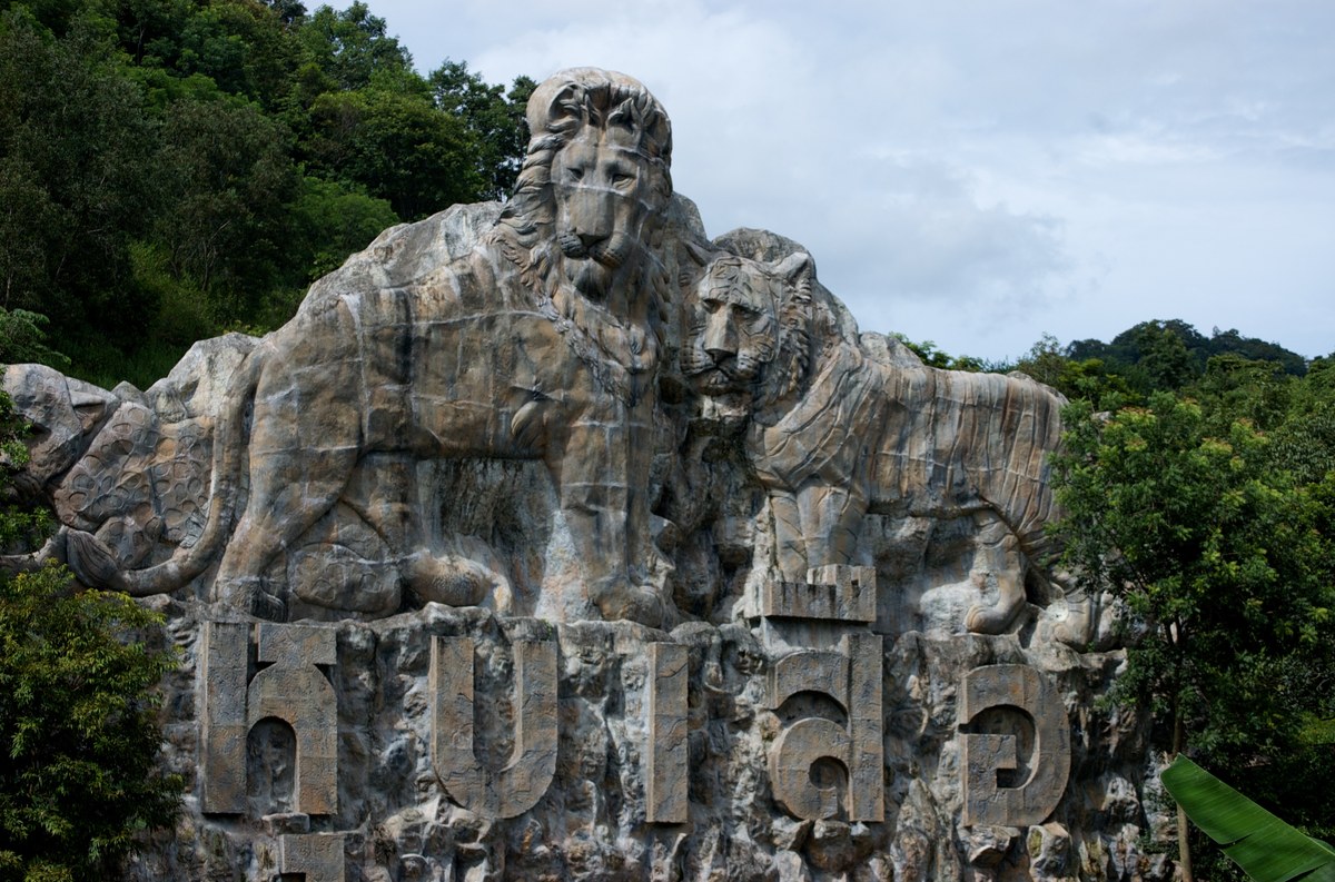 An outdoor sign bearing the Khao Kheow Open Zoo name and animal reliefs