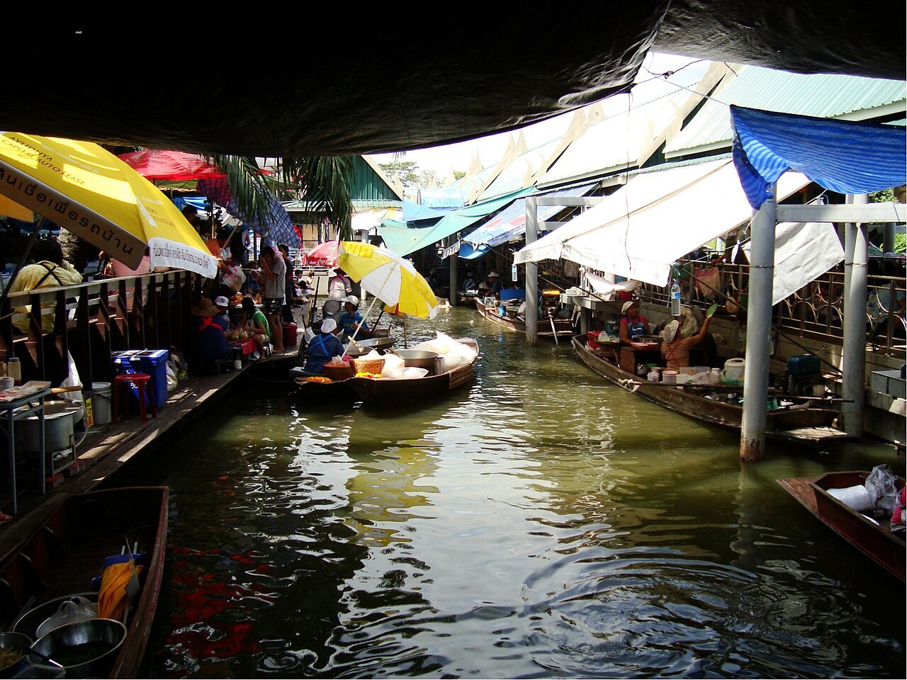 Canal and boats selling goods by the water at Taling Chan Floating Market